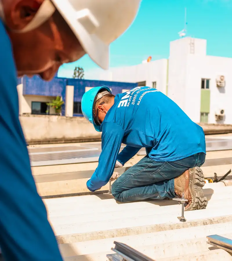 Instalador da Prime montando a estrutura dos painéis no telhado